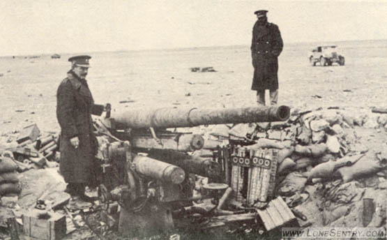 [These two pictures illustrate a German 88-mm. multipurpose gun that has been knocked out by British counterbattery fire. Notice that the hydropneumatic recuperator has been blown from its position above the tube. Also note ammunition containers in the foreground.]